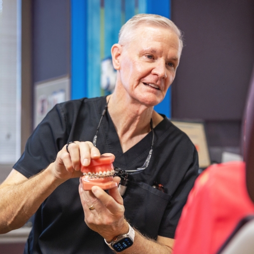 Dentist showing a young boy a model of the teeth